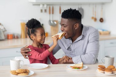 Güzel Afrikalı Amerikalı kız babasını besliyor.