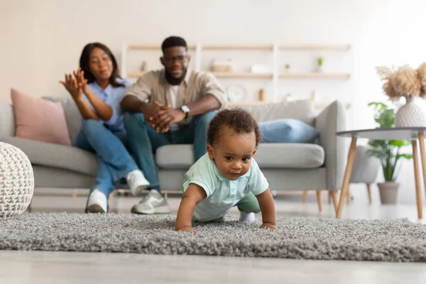 Schattige baby peuter wandelen in de woonkamer het maken van eerste stappen — Stockfoto