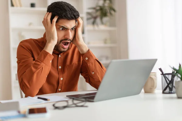 Geschokte Arabische man grijpen hoofd met behulp van laptop — Stockfoto