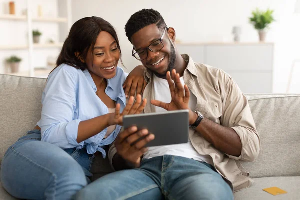 Zwart paar met videocall met behulp van tablet zwaaiende handen — Stockfoto