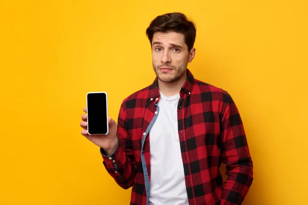 Triste cara segurando mostrando a tela do smartphone vazio — Fotografia de Stock