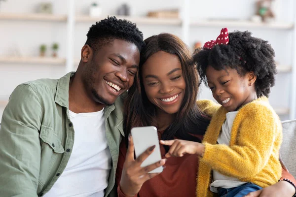 Geweldige app. gelukkig zwart familie met weinig dochter met behulp van smartphone thuis — Stockfoto