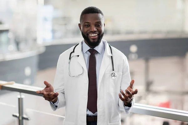Klinikte poz veren neşeli, yakışıklı zenci doktorun portresi. — Stok fotoğraf