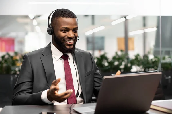 Negocio negro positivo teniendo videoconferencia con socios internacionales — Foto de Stock