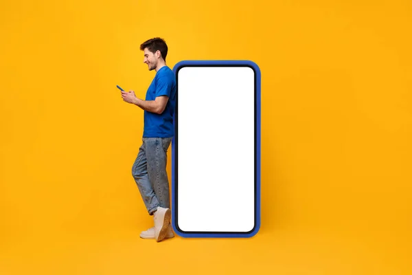 Mann stützt sich mit Handy auf weißen leeren Smartphone-Bildschirm — Stockfoto