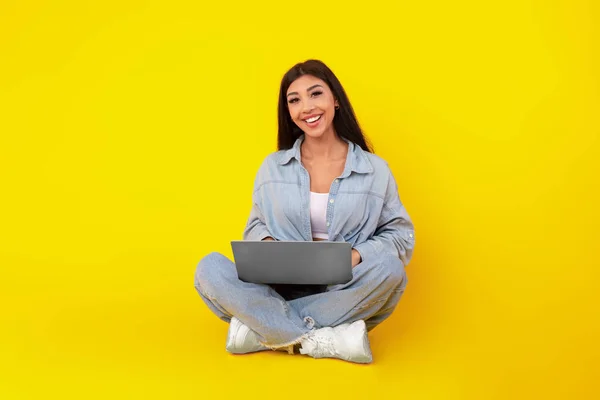 Joven alegre usando el portátil en el estudio — Foto de Stock