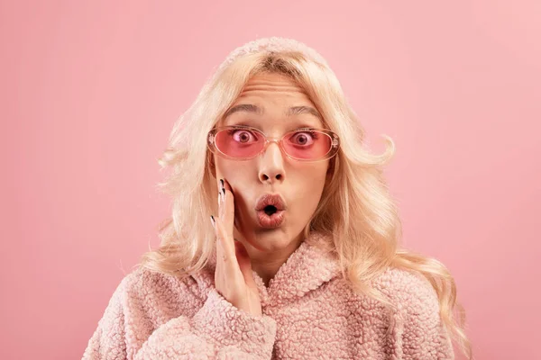 Omg-Angebot. Schockierte junge Frau mit Hand auf der Wange und aufgeregtem Blick in die Kamera, rosa Hintergrund, Studioaufnahme — Stockfoto