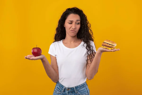 Elma ve Burger tutan Düşünceli Kadın Portresi — Stok fotoğraf