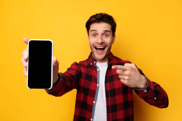 Geschokte man wijst naar zwart leeg smartphone scherm — Stockfoto