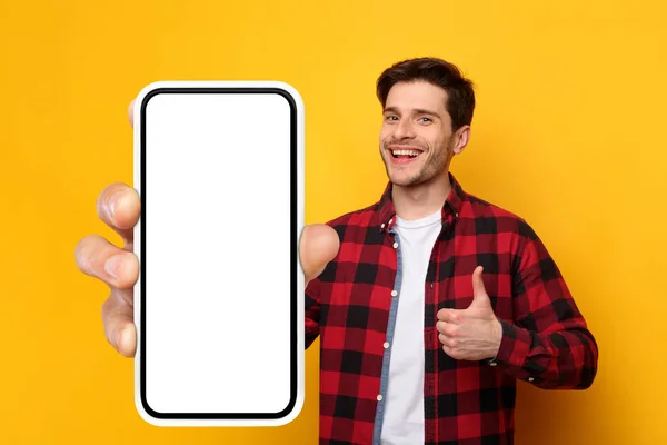 Χαρούμενος τύπος που δείχνει μεγάλη λευκή άδεια οθόνη smartphone και σαν — Φωτογραφία Αρχείου