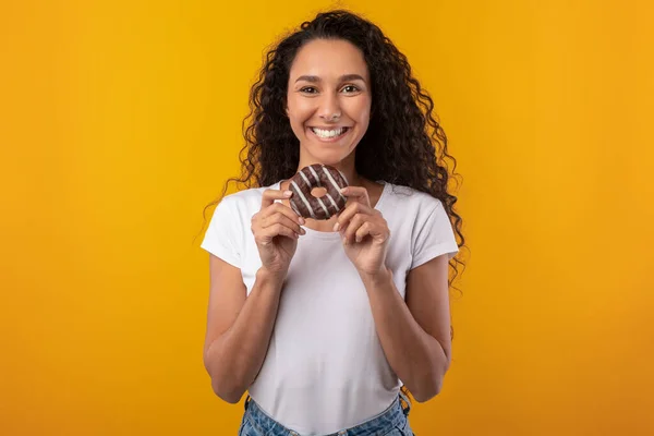 Senhora latina engraçada segurando bolo de donut no estúdio — Fotografia de Stock