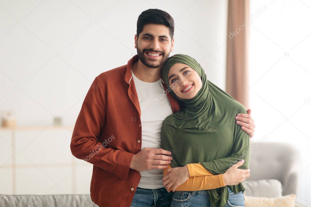 Loving Middle Eastern Couple Embracing Standing At Home