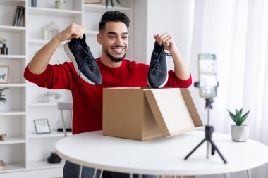 Boks videosu açılıyor. Arap erkek blogcu evdeki blogu için içerik kaydediyor