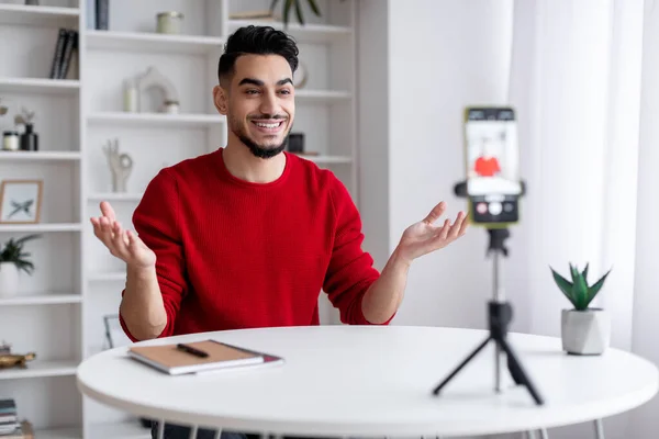 Genç Arap erkek blogcu üç ayaklı akıllı telefonuyla evde video kaydediyor — Stok fotoğraf