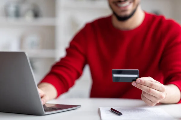 Handel elektroniczny. Uśmiechnięty Arab Man Korzystanie z laptopa i karty kredytowej do płatności online — Zdjęcie stockowe