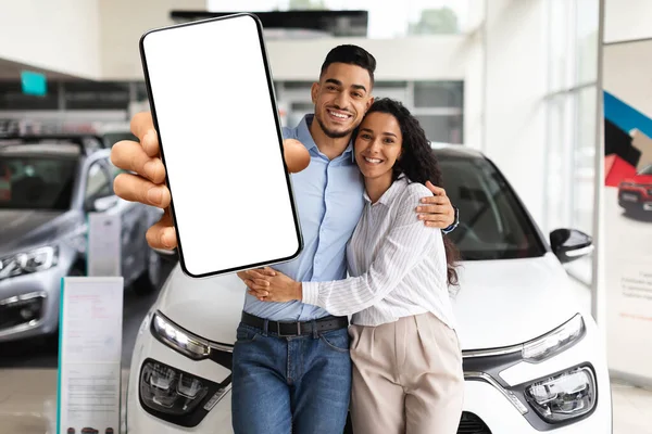 Feliz casal do Oriente Médio mostrando telefone celular, comprando novo automóvel — Fotografia de Stock