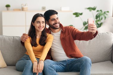 Neşeli Orta Doğulu Çift Evde Akıllı Telefon Kullanarak Selfie Çekiyor