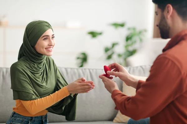 Мужчина с Ближнего Востока предлагает счастливой женщине показать кольцо в помещении — стоковое фото