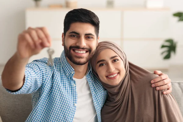 Gioioso mediorientale coppia mostrando chiave sorridente seduta a casa — Foto Stock