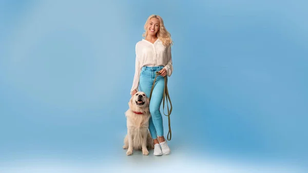 Ung kvinna poserar med sin hund i koppel — Stockfoto