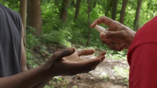 Orang kulit hitam yang tak bisa dikenali Menyemprot Sanitizer Pada Teman Tangan Di Luar — Stok Video