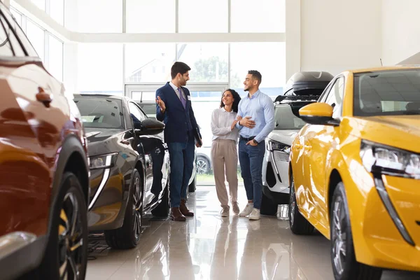 Arab man and woman choosing car at auto dealership — Stock Photo, Image