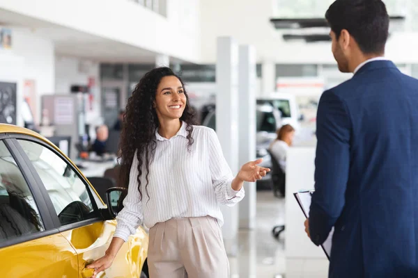 Senhora do Oriente Médio escolhendo carro novo, tendo conversa com gerente de vendas — Fotografia de Stock