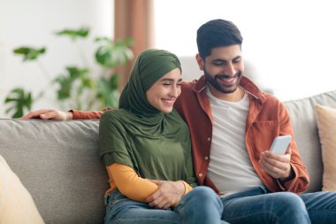 Olumlu Orta Doğulu Çift Evde Oturan Akıllı Telefonu Kullanıyor