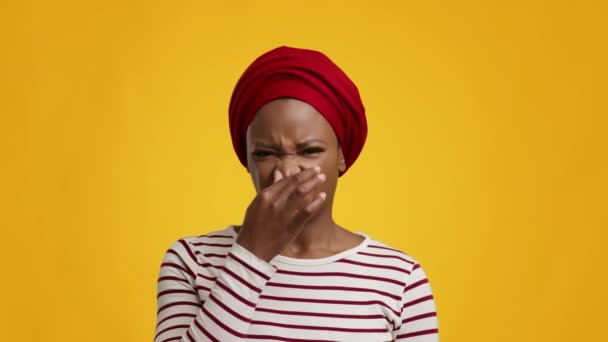 Disgusted Black Female Smelling Bad Stink Pinching Nose, Yellow Background — Stock Video