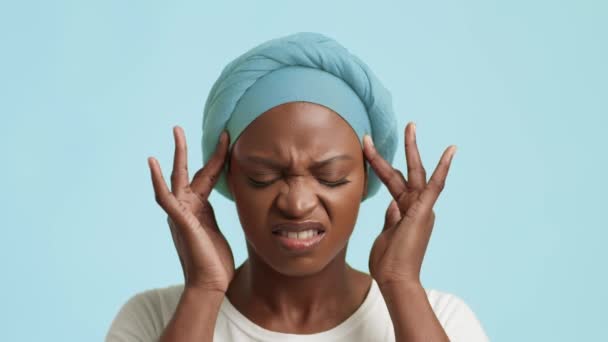 Μαύρη κυρία που υποφέρει από πονοκέφαλο μασάζ ναούς πάνω από το μπλε φόντο — Αρχείο Βίντεο