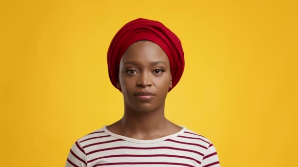 Retrato de una dama africana seria usando un abrigo rojo, fondo amarillo — Vídeo de stock