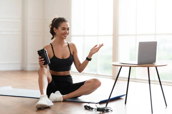 Молодая женщина упражнения с онлайн-тренером с помощью ПК — стоковое фото