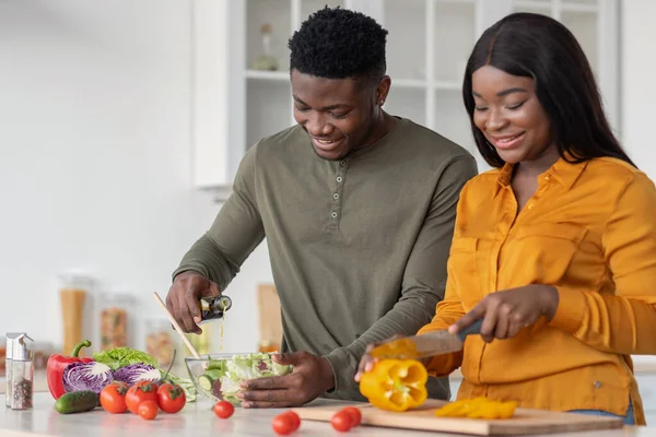 Cocinando juntos. Jóvenes amantes afroamericanos preparando comida en la cocina — Foto de Stock