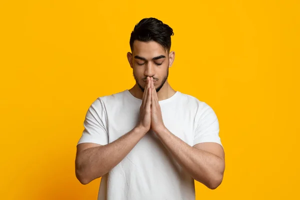 Retrato de un joven religioso de Oriente Medio rezando sobre amarillo — Foto de Stock