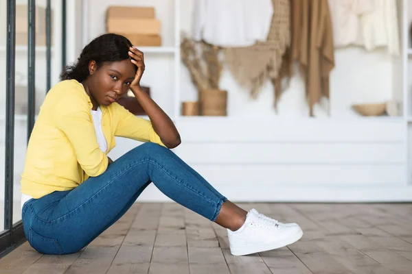 Deprimida mujer negra sentada expresando tristeza sintiéndose sola en casa —  Fotos de Stock