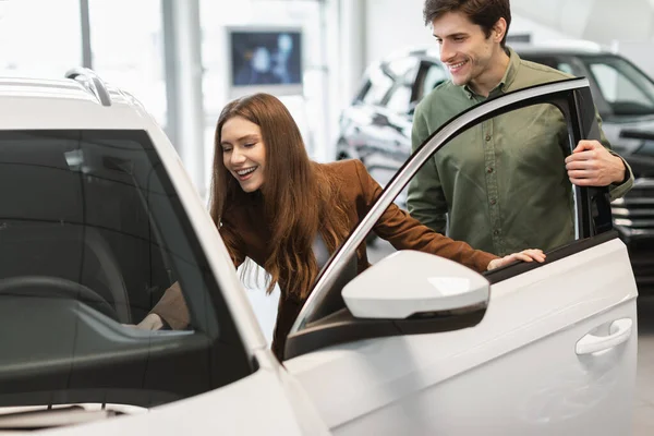 Heureux jeune couple caucasien vérifier nouveau salon de voiture, la sélection de l'automobile moderne au magasin concessionnaire — Photo