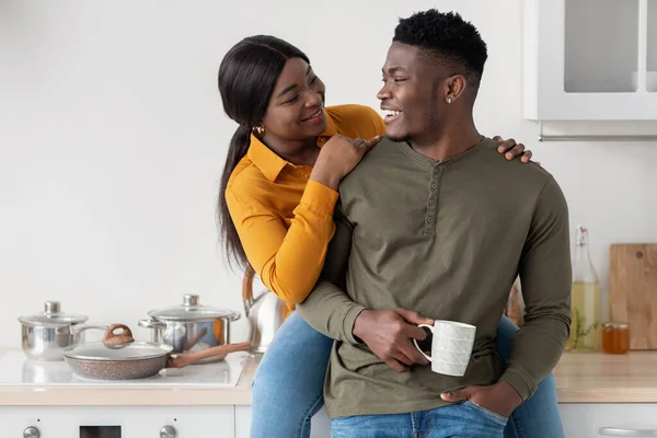 Romantique jeune couple afro-américain étreignant et buvant du café dans la cuisine intérieure — Photo