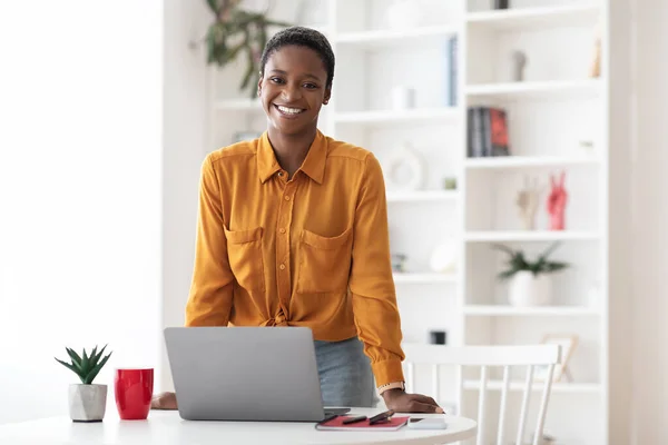 Positive short-haired african american woman posing at office
