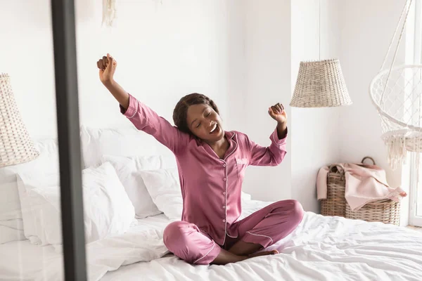 İyi uyuyan Afrikalı Kadın Esneme Kollarını esneten Modern Yatak Odasında Oturan — Stok fotoğraf