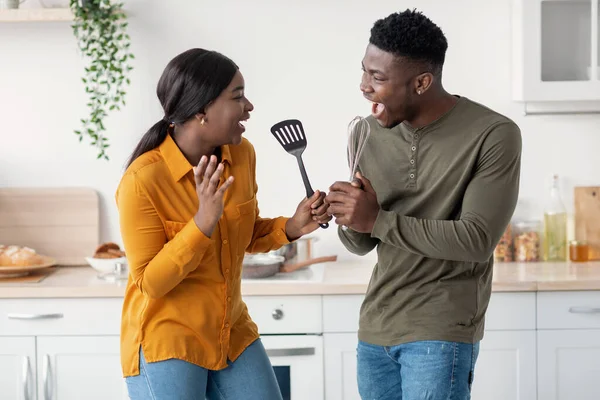 Imbrogliare insieme. Gioioso nero sposi having divertimento in cucina interior — Foto Stock