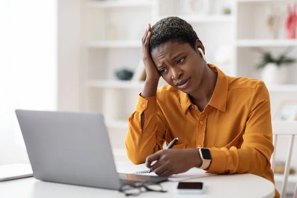 Verveeld zwart dame wonen webinar, zitten in de voorkant van laptop — Stockfoto