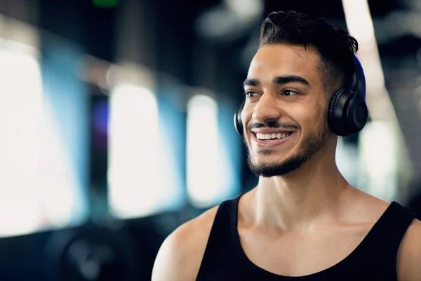 Nahaufnahme Porträt eines hübschen lächelnden Mannes aus dem Nahen Osten mit drahtlosen Kopfhörern — Stockfoto
