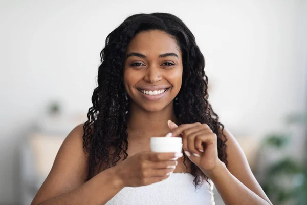 Mooie afrikaanse amerikaanse dame met behulp van body cream na douche — Stockfoto