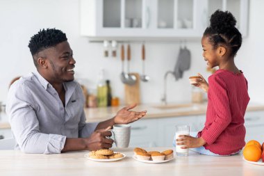 Afro-Amerikan ailesi yemek yerken sohbet ediyor.