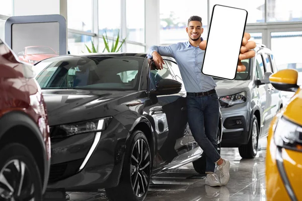 Gazdag közel-keleti férfi pózol az autó mellett, okostelefont mutat — Stock Fotó