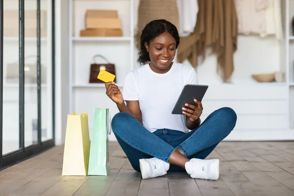 Compras femininas pretas usando cartão de crédito e tablet em casa — Fotografia de Stock