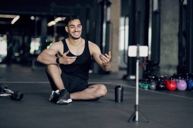Yakışıklı Arap erkek fitness blogcusu Smartphone Camera at Gym 'de video kaydediyor