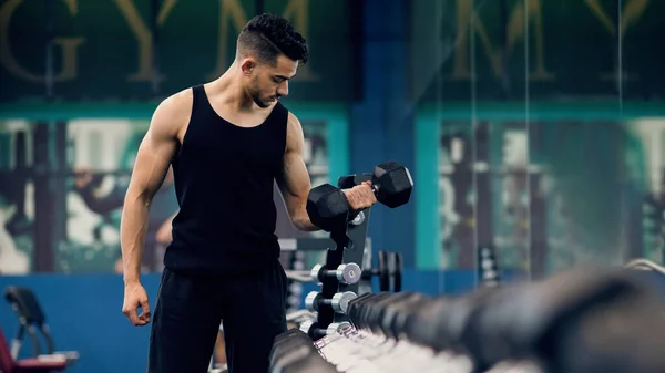 Conceito de halterofilismo. Muscular jovem árabe homem treinando com halteres no ginásio — Fotografia de Stock