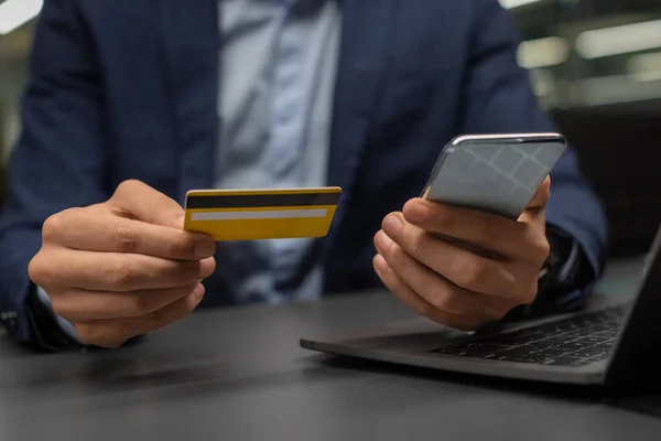 Beskärs av affärsman som använder smartphone, innehar kreditkort — Stockfoto