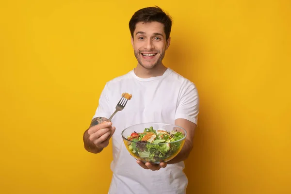 Retrato del chico sonriente sosteniendo el tazón con ensalada — Foto de Stock